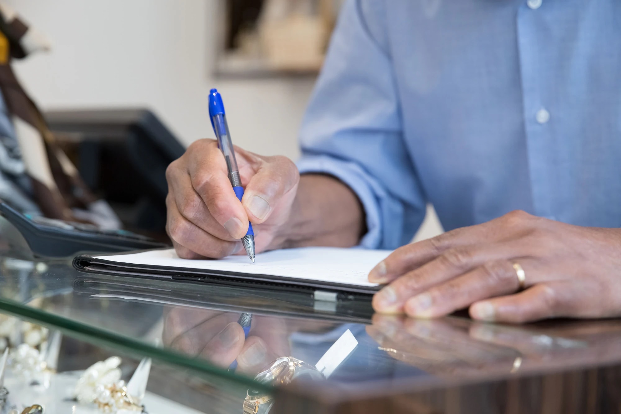 Someone filling in a form at an office counter