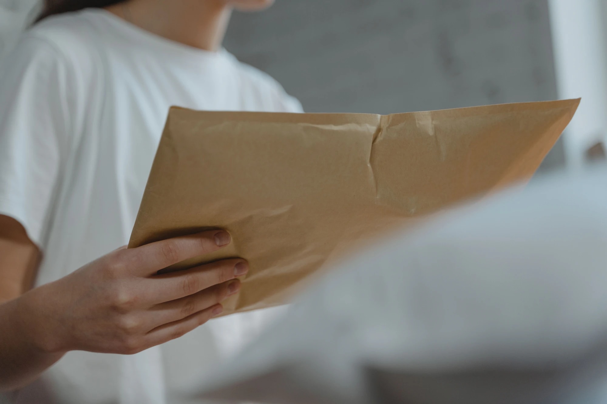 Hands passing over a brown paper envelope